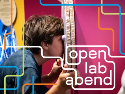 Ein Junge sieht durch eine Pappkonstruktion hindurch.