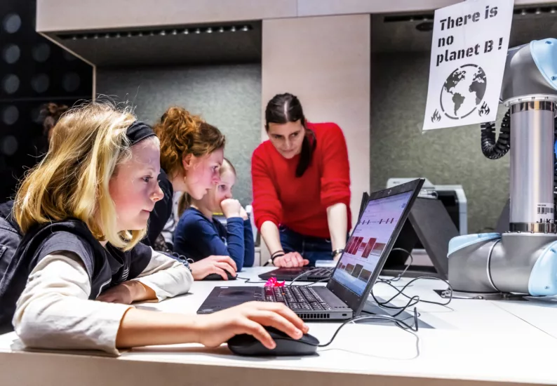Kinder und Erwachsene bedienen einen Computer im Lab