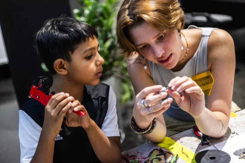 Eine Frau erklärt einem Jungen ein elektrisches Bauteil