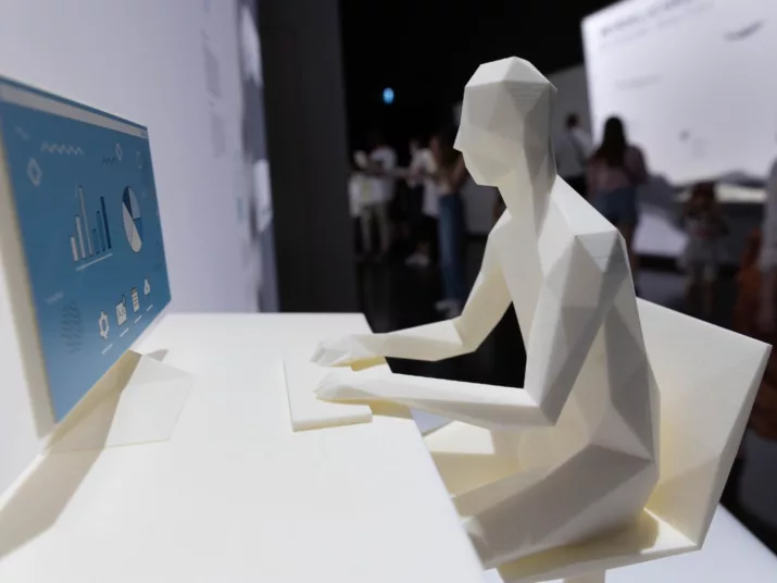 Kunststoff-Figur einer Person am Computer