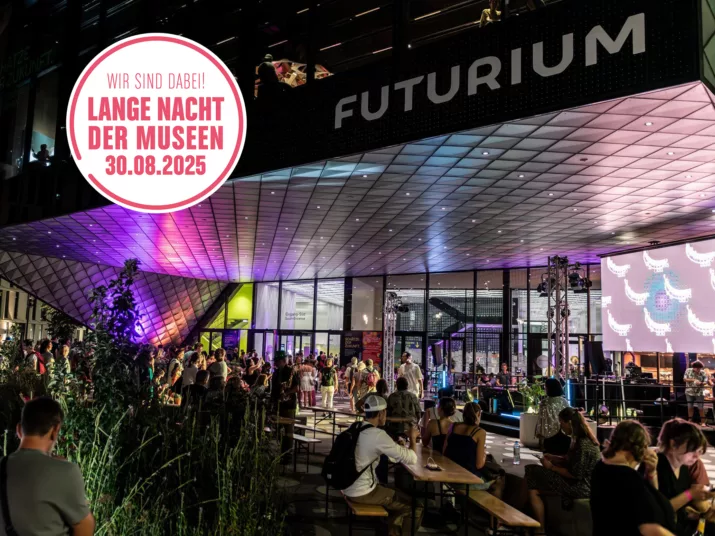People sitting in front of the colourfully lit Futurium