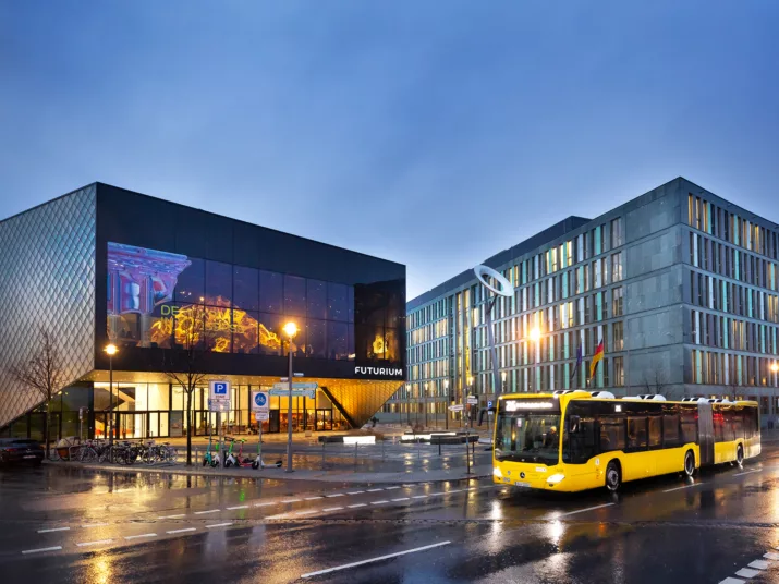 Bus fährt in der Dämmerung am Futurium vorbei