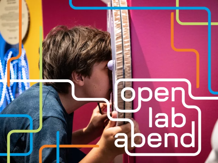 Ein Junge sieht durch eine Pappkonstruktion hindurch.