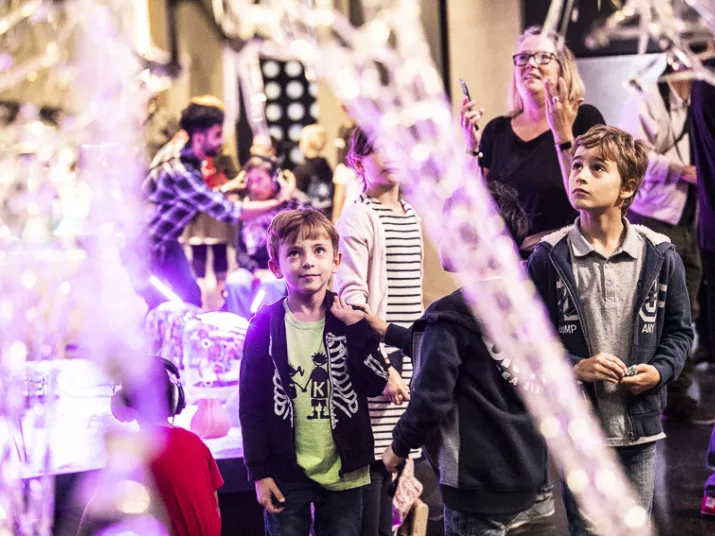 Kinder betrachten Exponate im Lab. Im Vordergrund hängt eine Skulptur